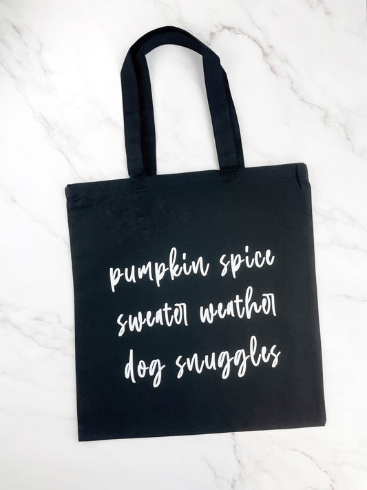 Black tote bag that reads "pumpkin spice sweater weather dog snuggles"