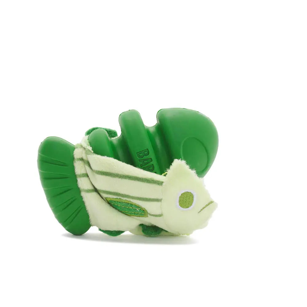 Isolated green cod dog toy that is showing hard plastic that  is underneath its soft cloth cover