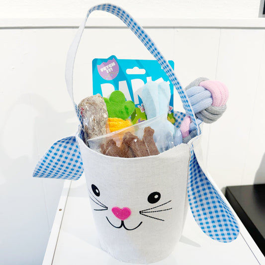 Blue patterned Easter basket for dogs that contains many treats and toys