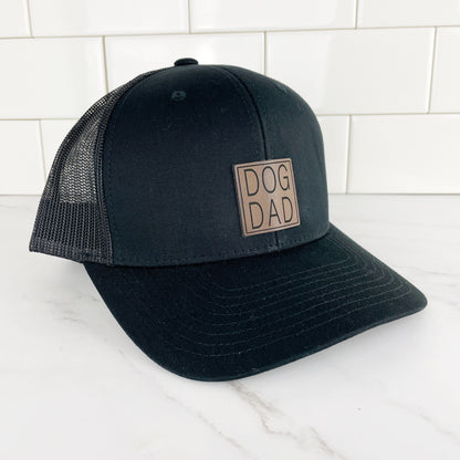 black dog dad trucker hat with mesh back and a dog dad leather patch