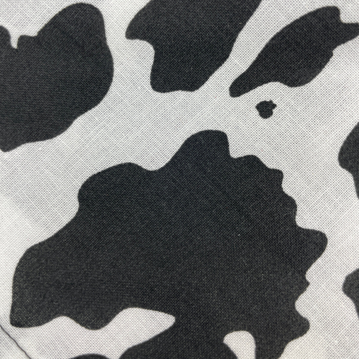 Close-up view of a cow print dog bandana