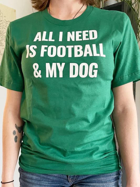A green t-shirt that says "ALL I NEED IS FOOTBALL AND MY DOG" in white bold lettering.