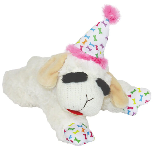 Isolated plush Lamb Chop toy wearing a white birthday party hat with a colorful bone pattern and pink ball on top