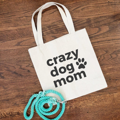 crazy dog mom tote bag with a bright blue leash coiled and resting on the bottom corner of the tote bag